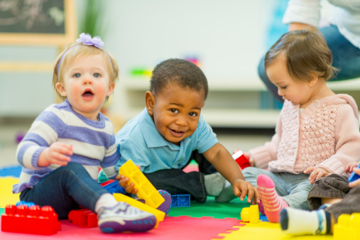 Three babies playing with blocks