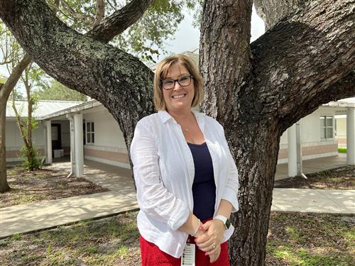 Mrs. Johnson standing outside near a tree.