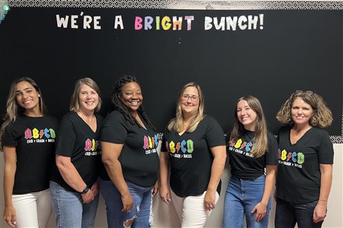 Second Grade Teacher in front of bulletin board that reads, We're a Bright Bunch!