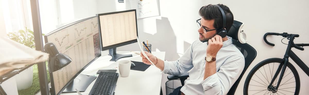 Man sitting in a chair at a desk working with headphones