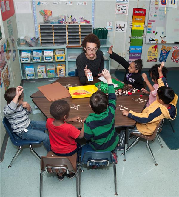 A Student Helping the teacher teach little kids in the teacher assistant class