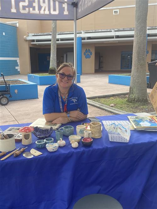 Ms. Bustamante at booth with pottery