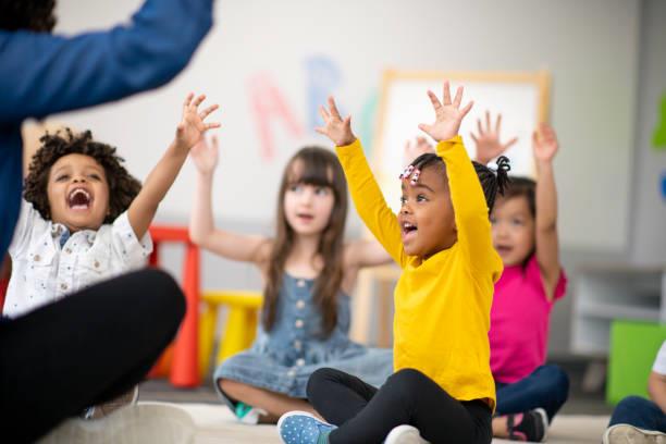 Kids sitting down in a classroom participating in class 