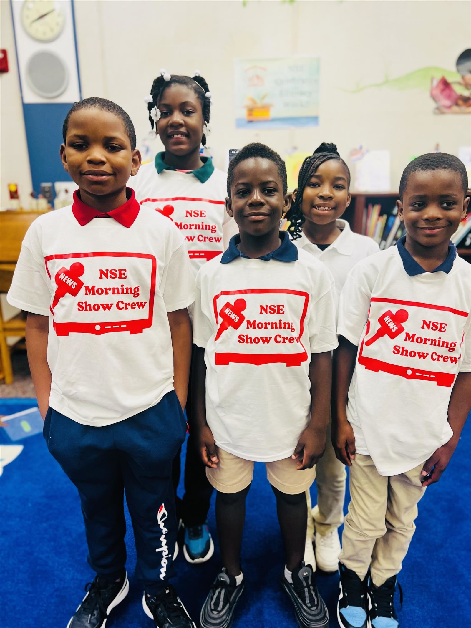 STUDENTS STANDING WITH THEIR NSE MORNING SHOW CREW T-SHIRT 