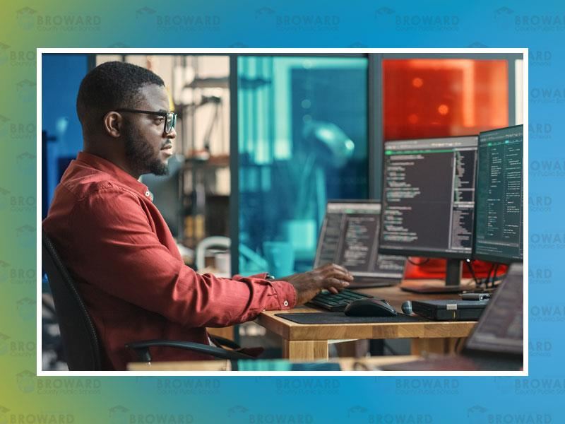 man looking at codes on a computer screen