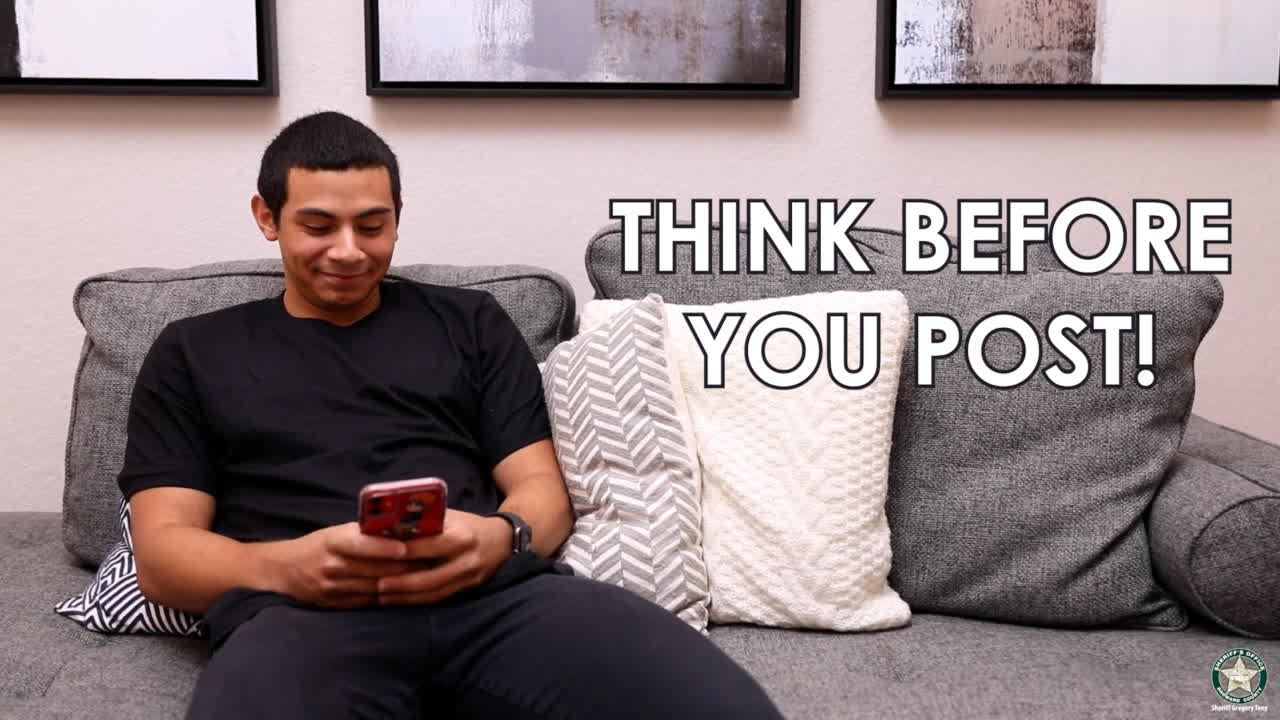  Young man sitting on sofa looking at a cell phone.