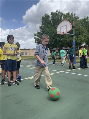student kicking a soccer ball