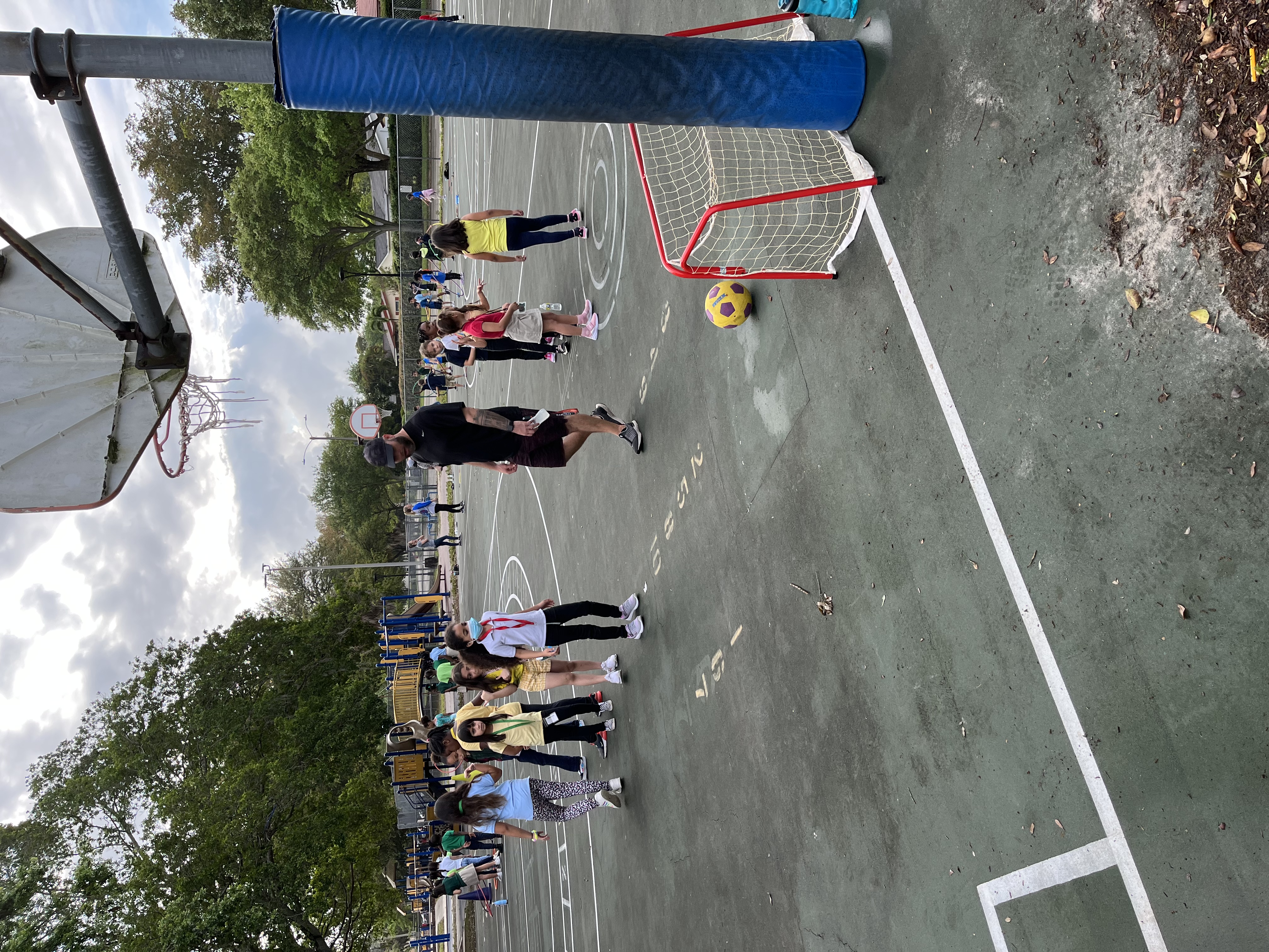 students lining up to kick ball into net