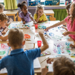  Elementary students in art class painting at a table